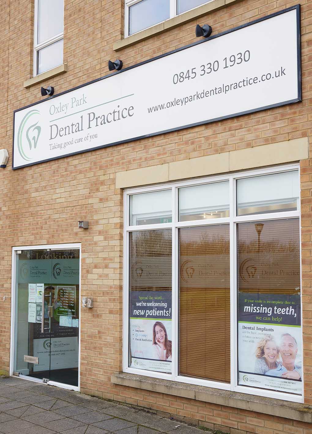 Exterior of Oxley Park Dental Practice with signage and window posters.