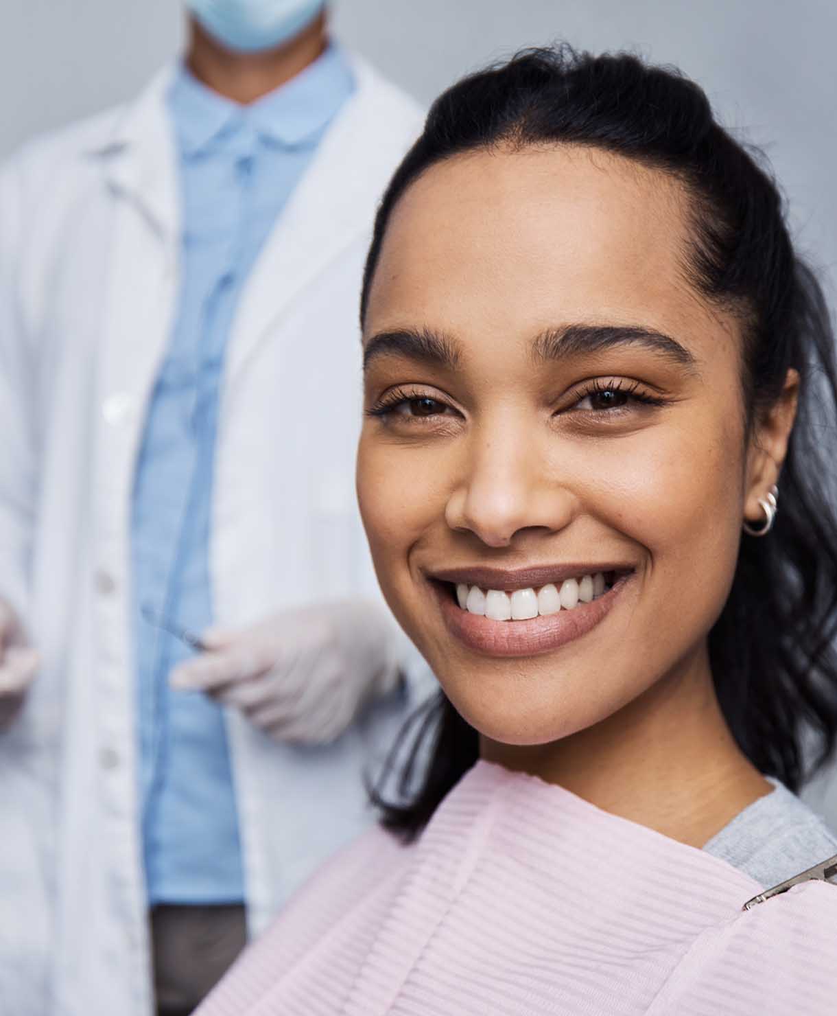 Woman smiling with a healthcare professional in the background