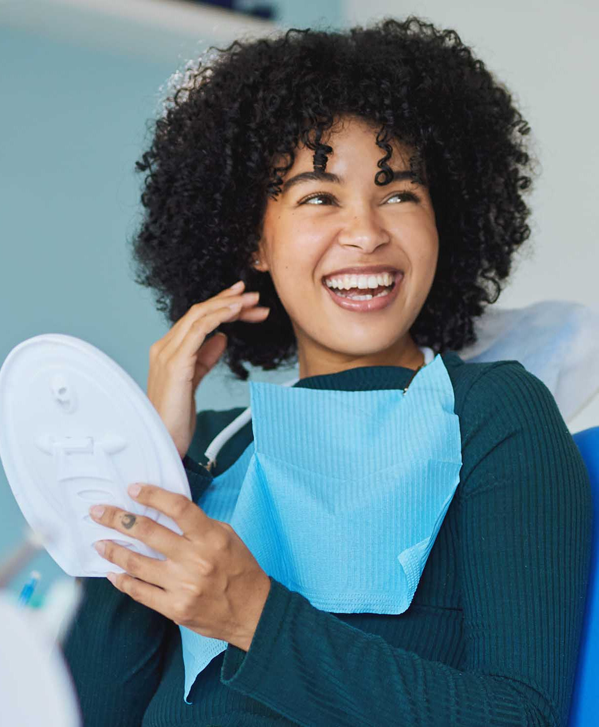 Woman holding a white shoe with a blue bib, possibly in a dental office setting