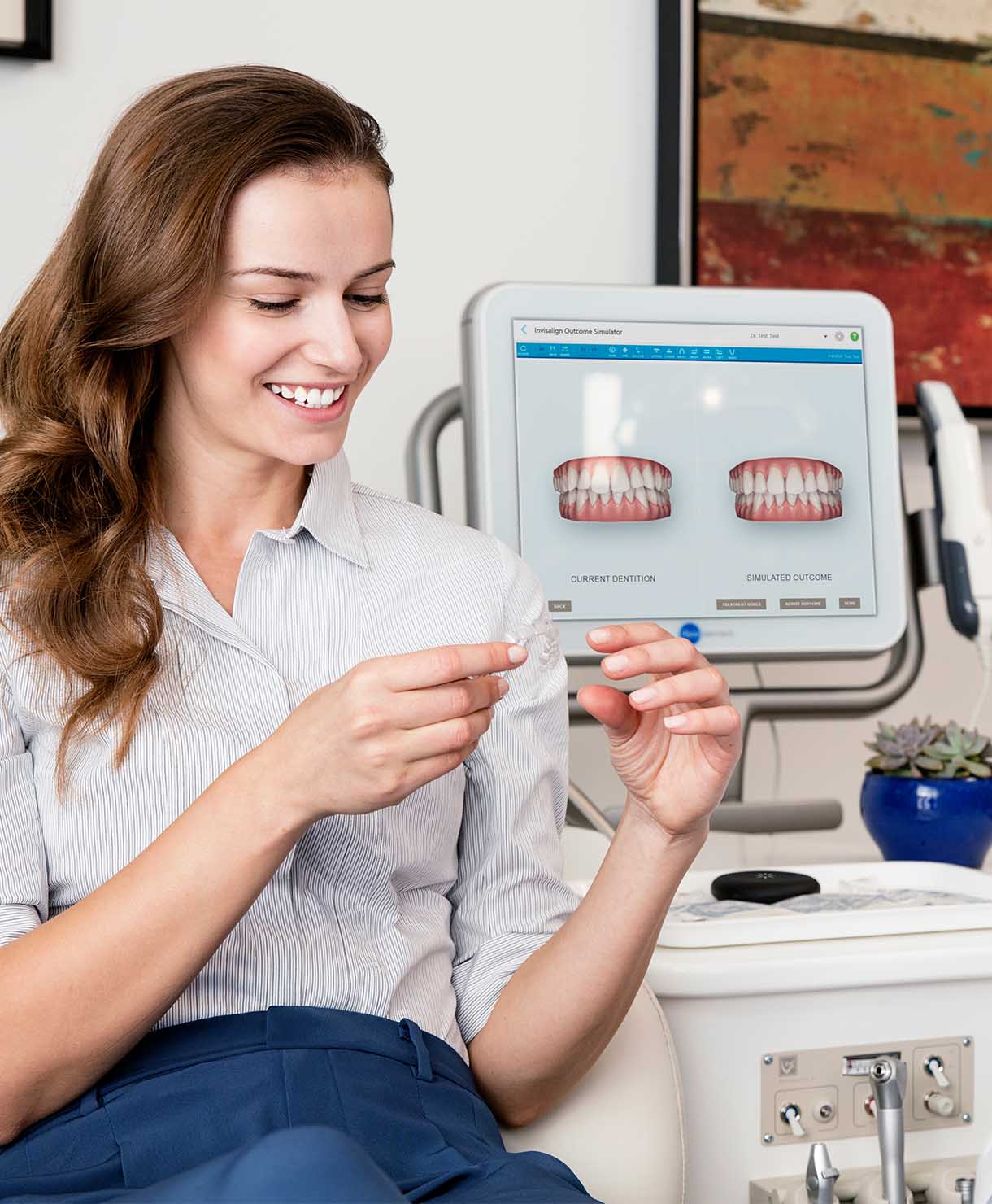 Woman using dental imaging software on a tablet in a dental office.