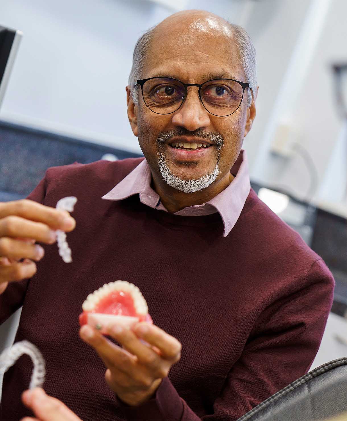 Man holding dental models in a clinical setting