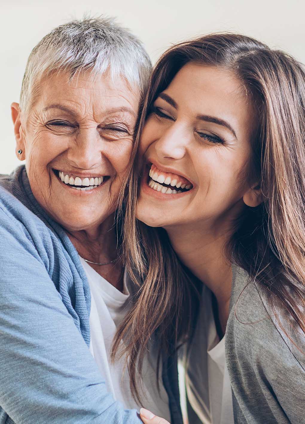 Two women smiling and embracing each other