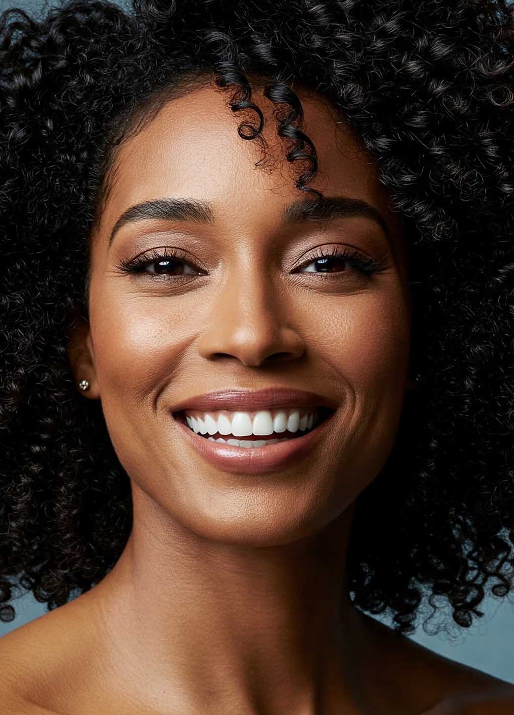 Close-up of a woman with a bright smile against a blue background